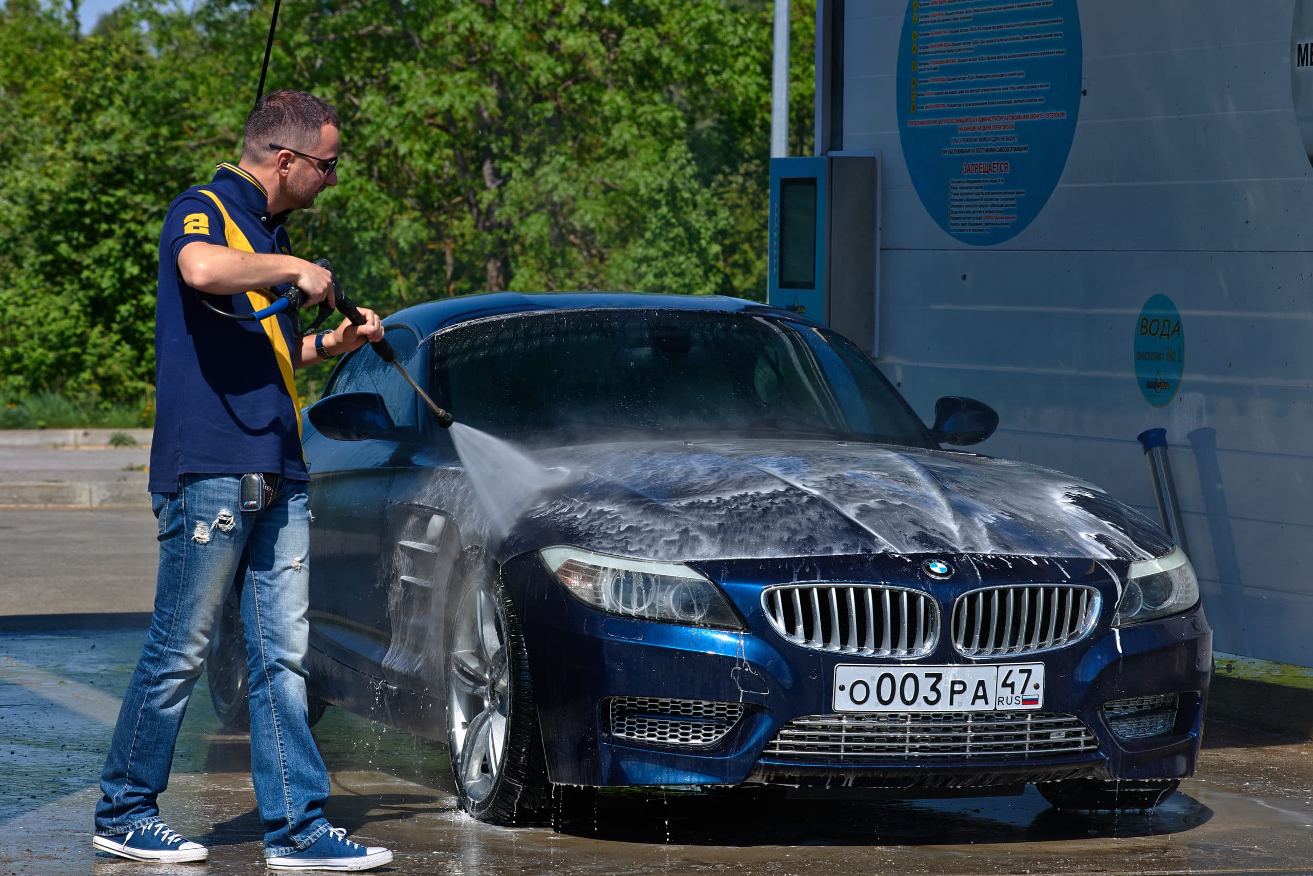 мужчина моет машину